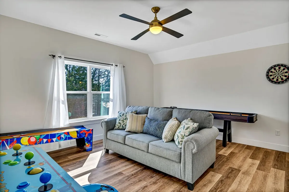 Here, a comfortable sofa is paired with a dartboard and game table, set in a playful, cozy environment. The scene is ideal for gatherings, game nights, and casual lounging, rounding out the game loft’s versatile appeal.