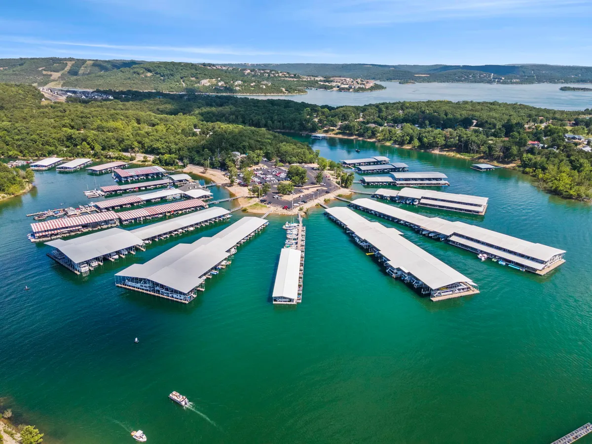 A peaceful exterior scene at the marina docks, with boats floating on calm water, surrounded by greenery and a soft sunset in the background. The inviting docks suggest opportunities for boating, fishing, and lakeside exploration just minutes from Branson Cove.